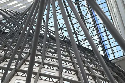 Modern building interior with steel beams and glass ceiling, representing structural frameworks